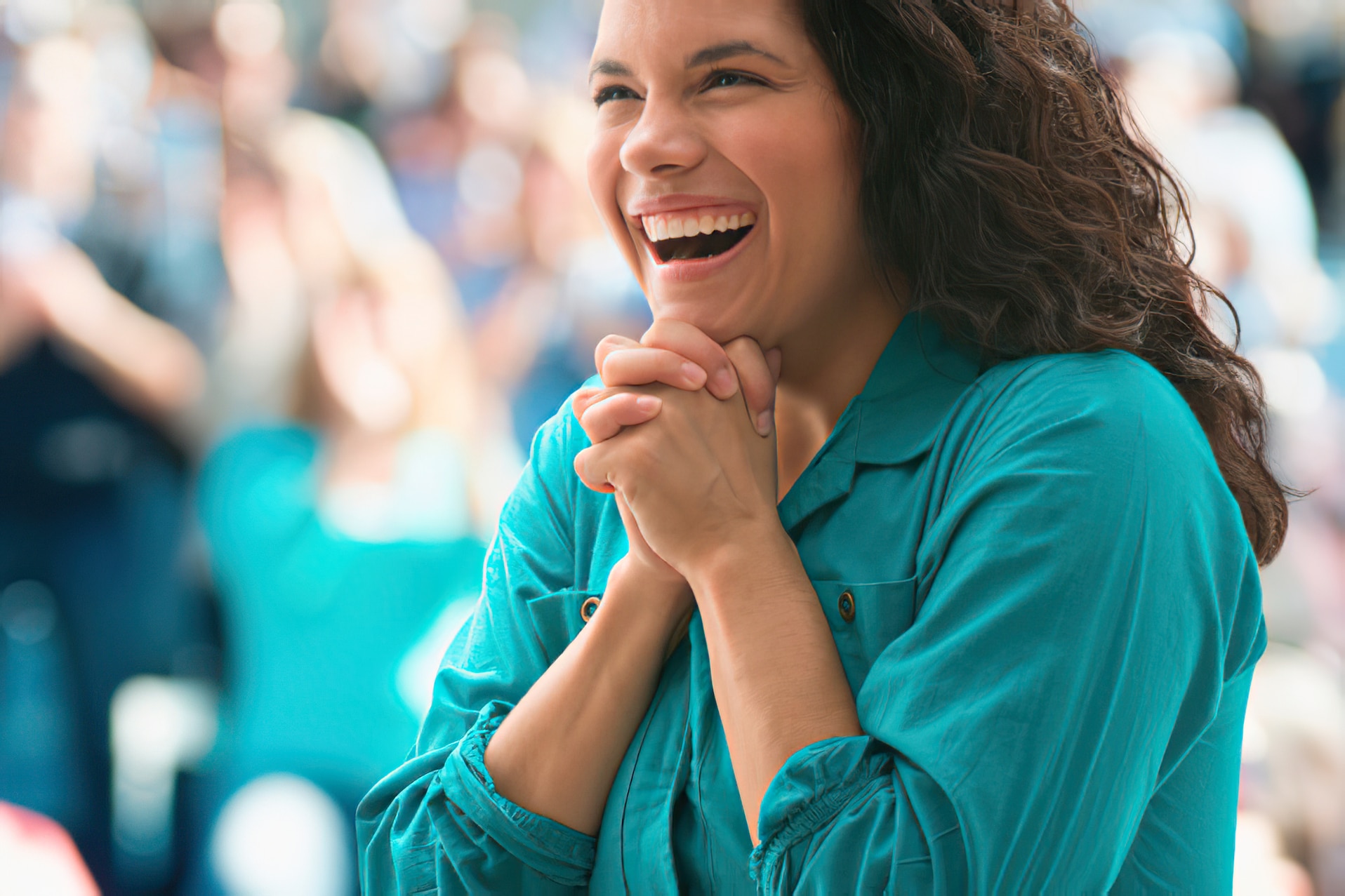 Woman in a teal shirt smiling.