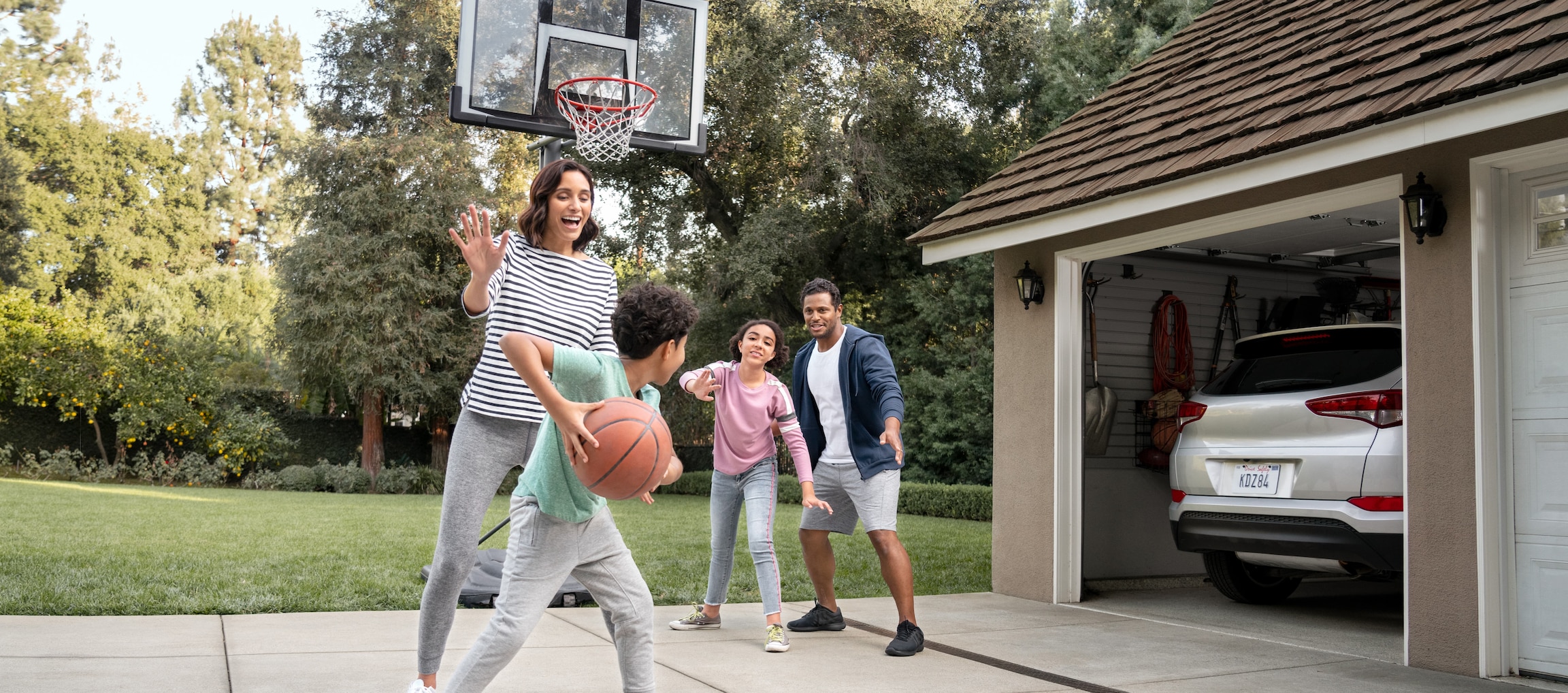 Family playing some basketball in their driveway