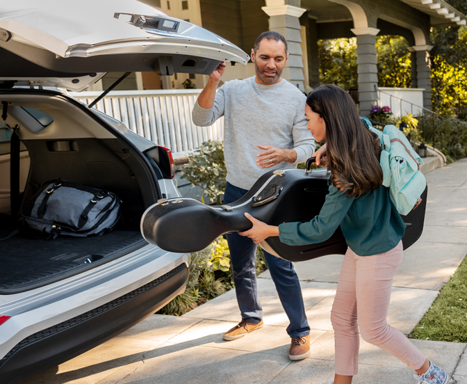 Dad helping daughter pack the back of a SUV