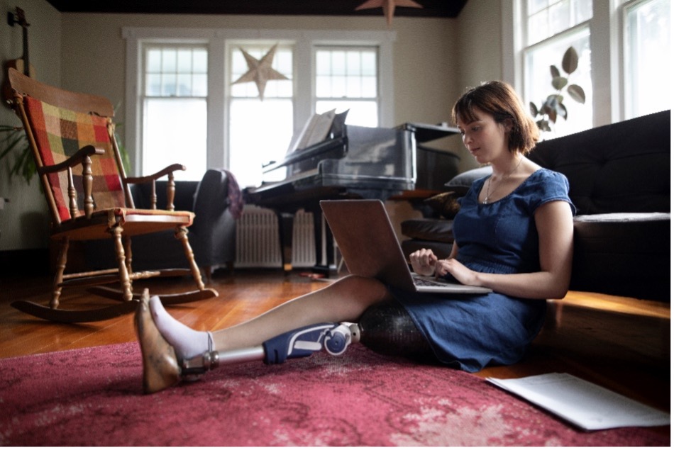 woman with prosthetic leg searching for car insurance on a laptop