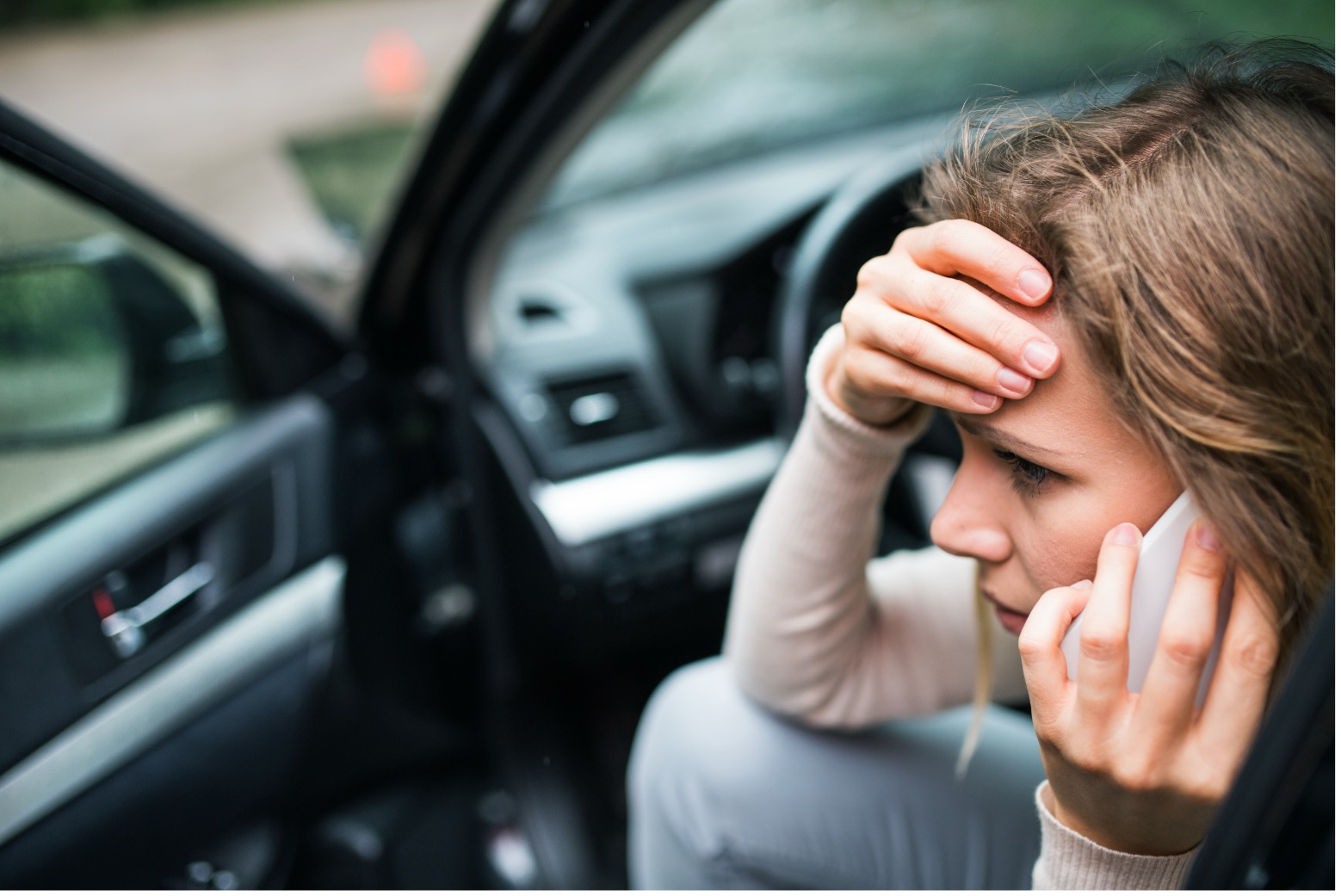 Woman in car on phone after minor crash