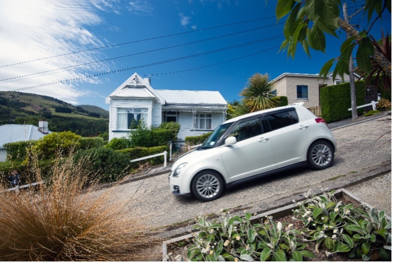 White car on a steep residential street