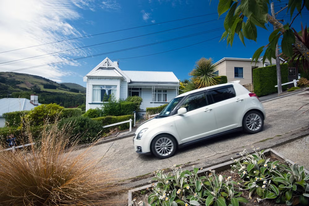 White car on a steep residential street