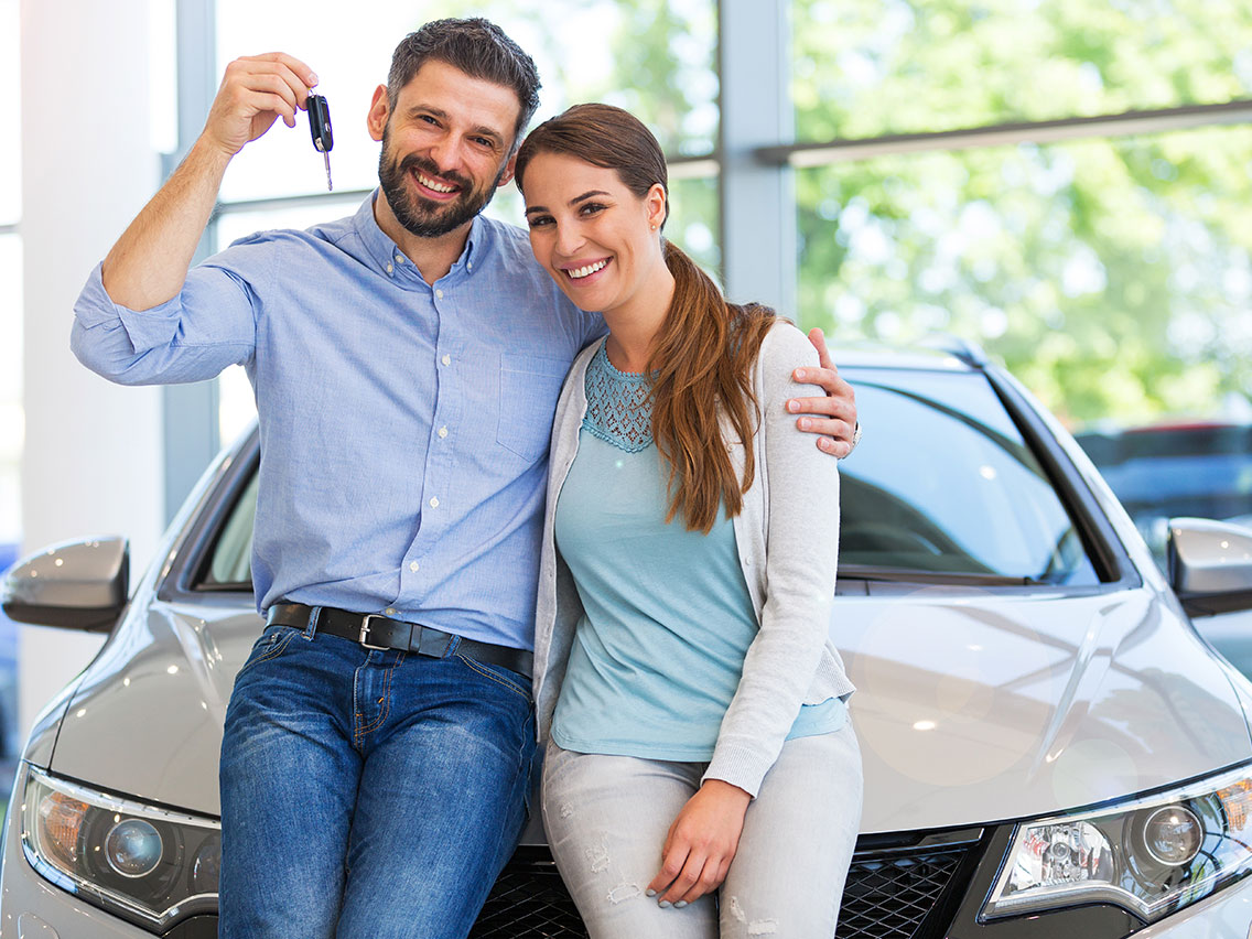 Couple with keys to a new car