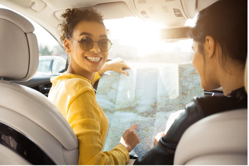 Car interior with two people reviewing a map