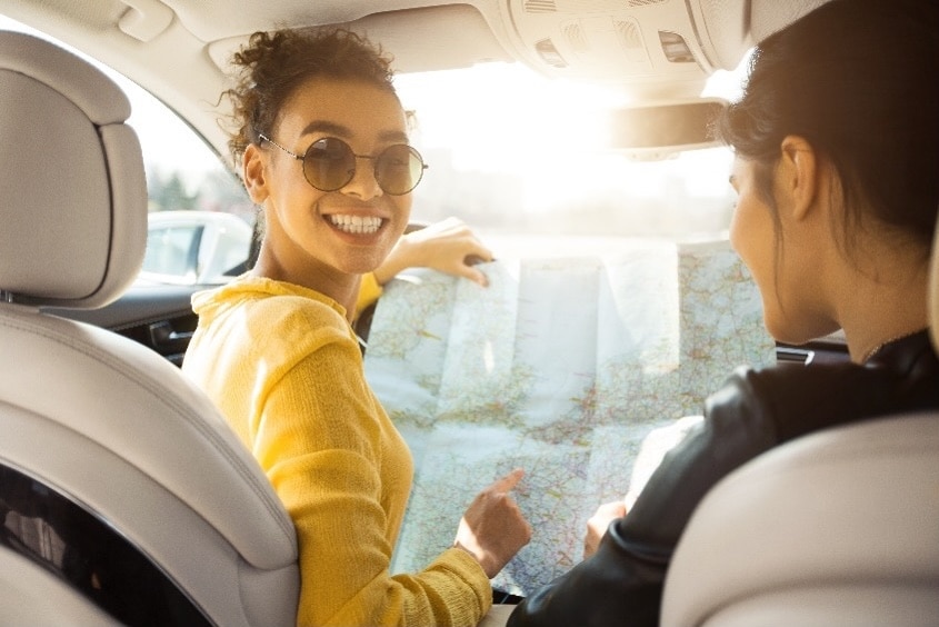 Car interior with two people reviewing a map
