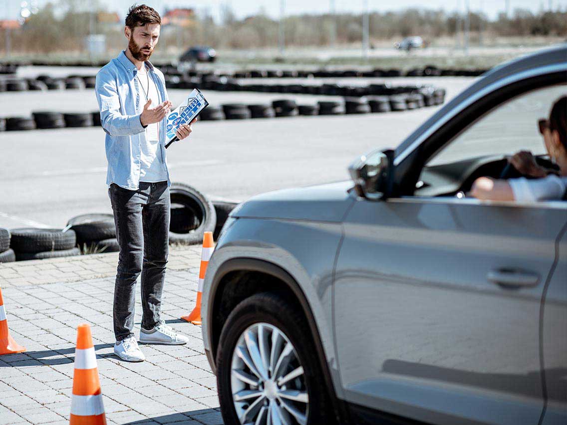 Teenager practicing parking with a driving instructor.