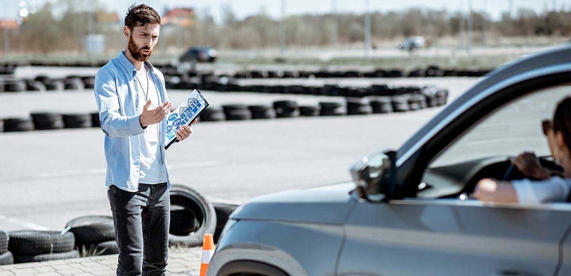 Teenager practicing parking with a driving instructor.