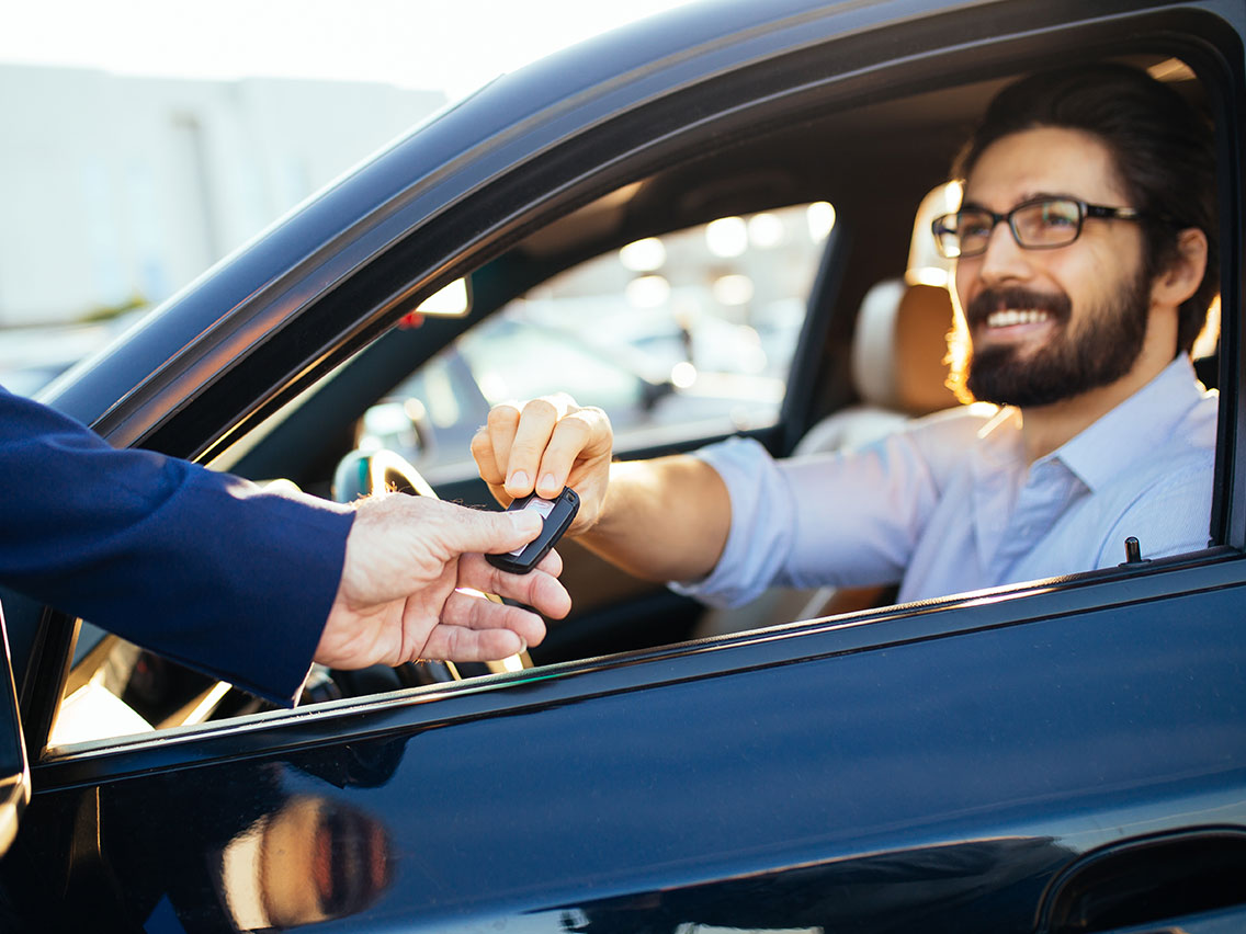 Man taking the keys to the car he just bought