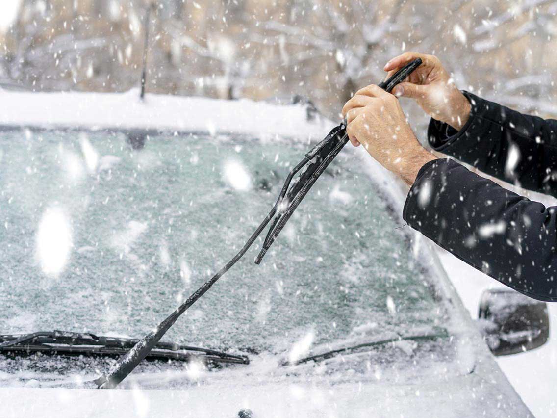 Person clearing off the windshield of their car