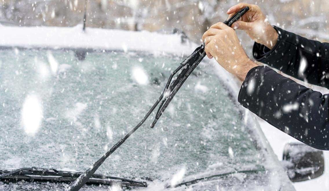 Person clearing off the windshield of their car