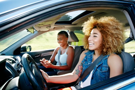 two women riding in a car laughing