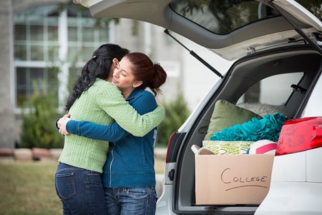 mother and daughter hugging after packing up the car before daughter heads off to college