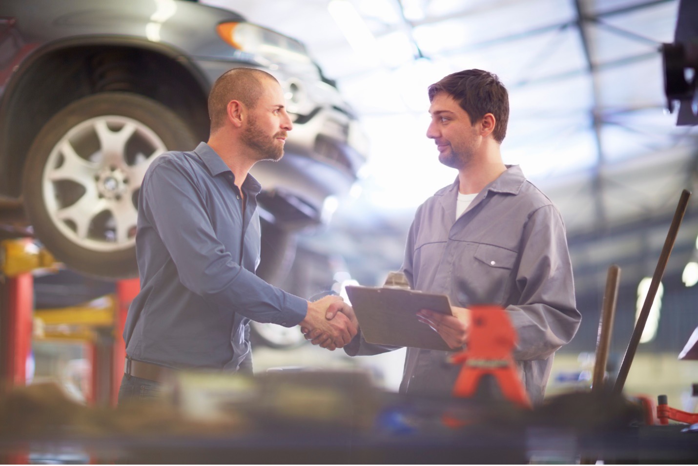 mechanic and customer shaking hands in repair shop