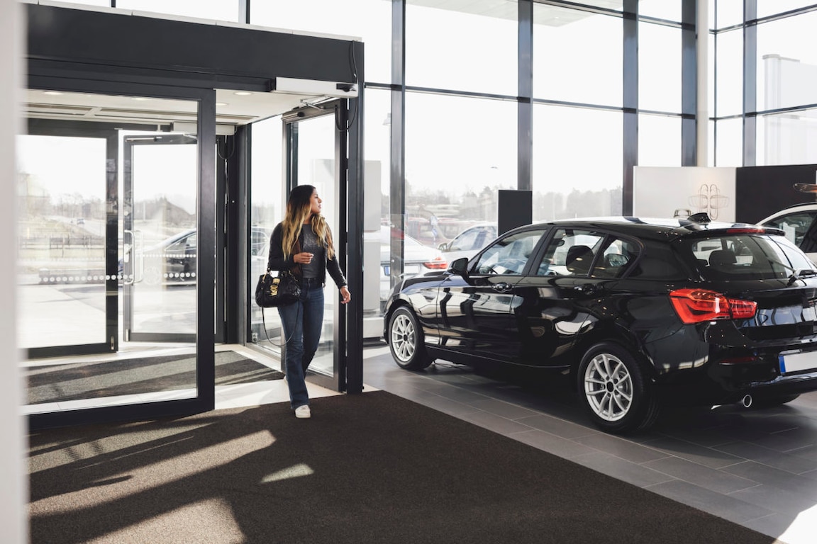 woman walking into car dealership