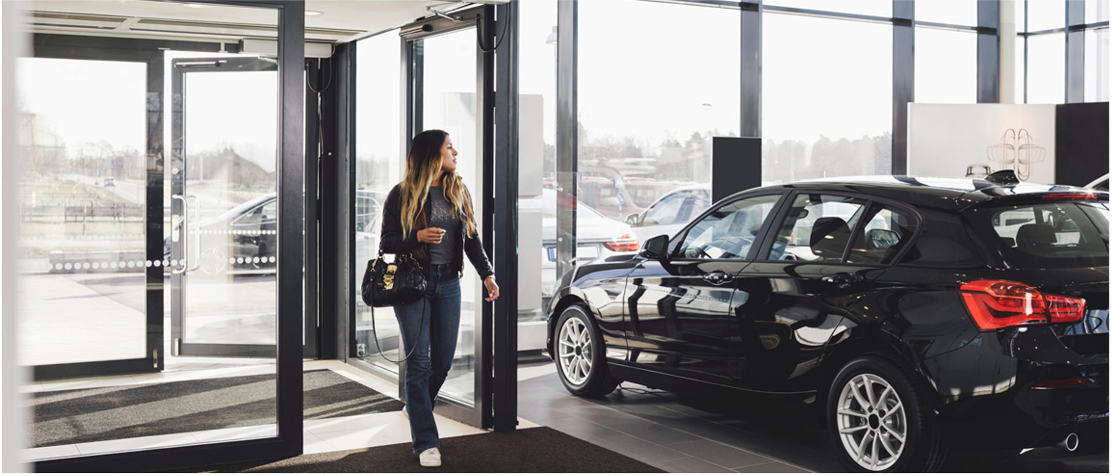 Woman walking into car dealership