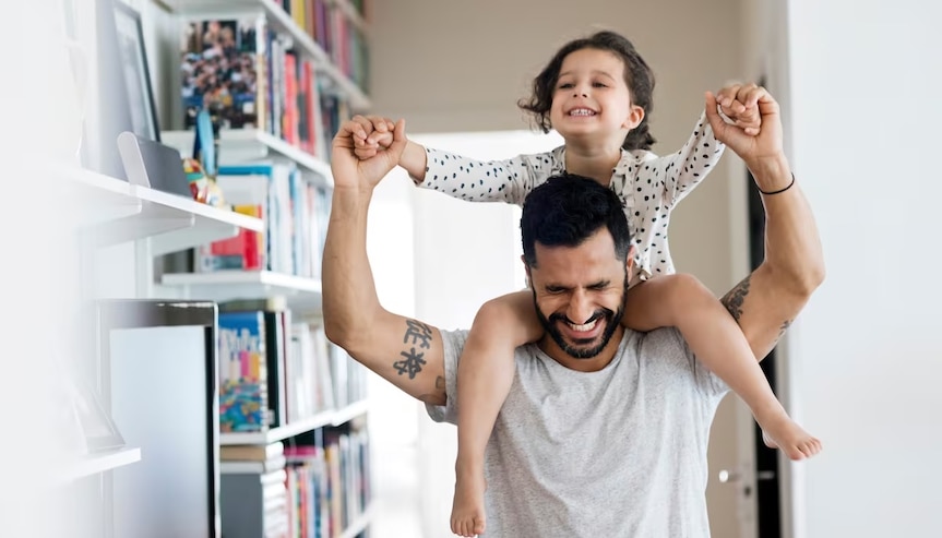 child riding on dad's shoulders