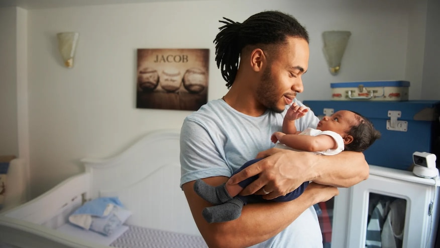 Smiling man holding a happy baby