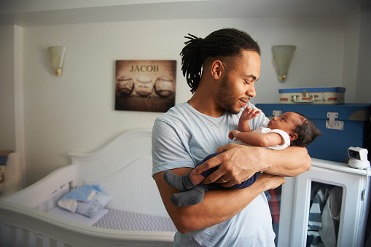 Smiling man holding a happy baby