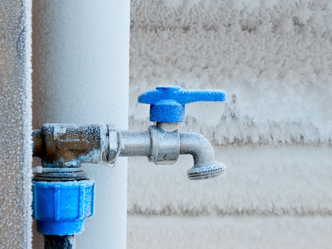 outdoor hose spigot covered in ice