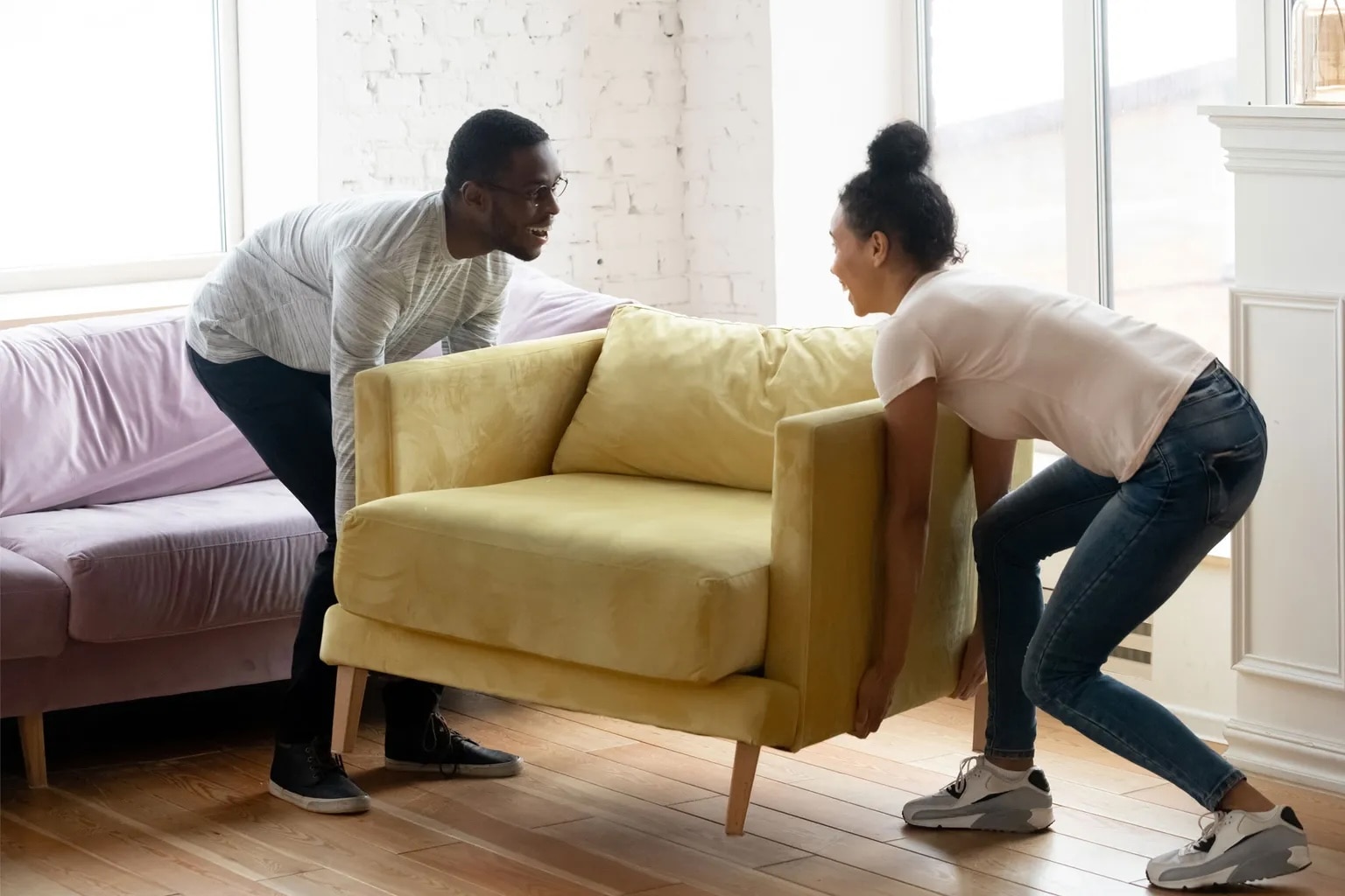 Couple moving a chair in their new apartment