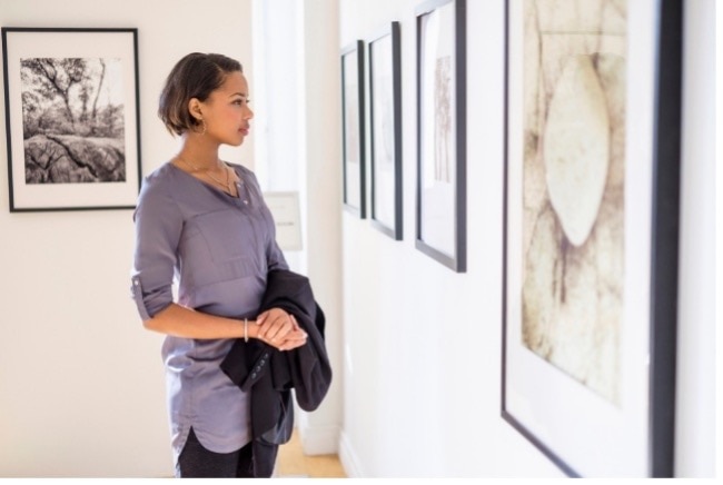 Woman looking at a painting in an art gallery