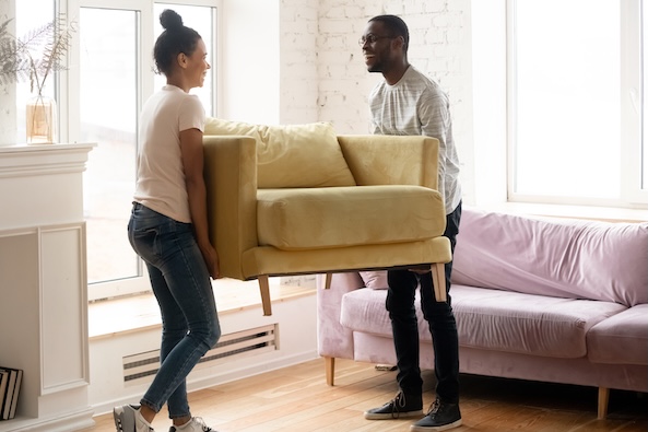 Couple moving a chair in their new apartment