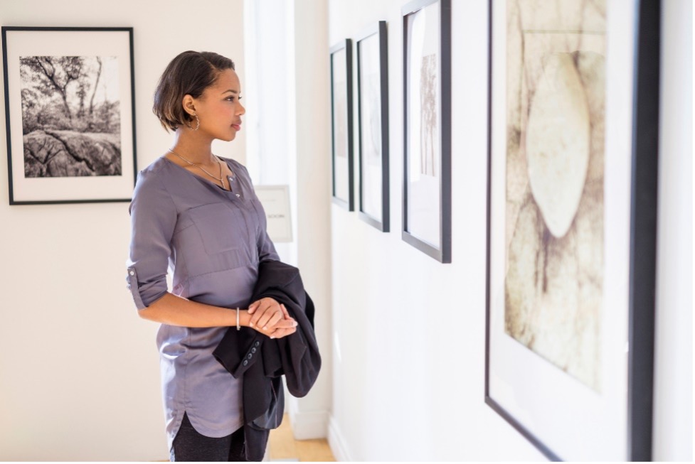 Woman looking at fine art on wall