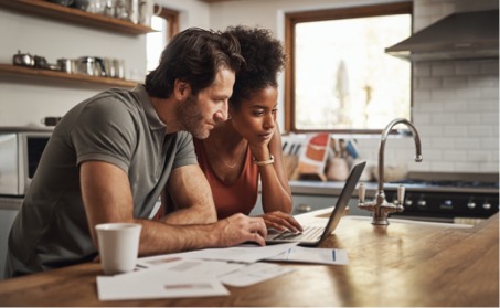 Couple comparing homeowners insurance quotes on their laptop