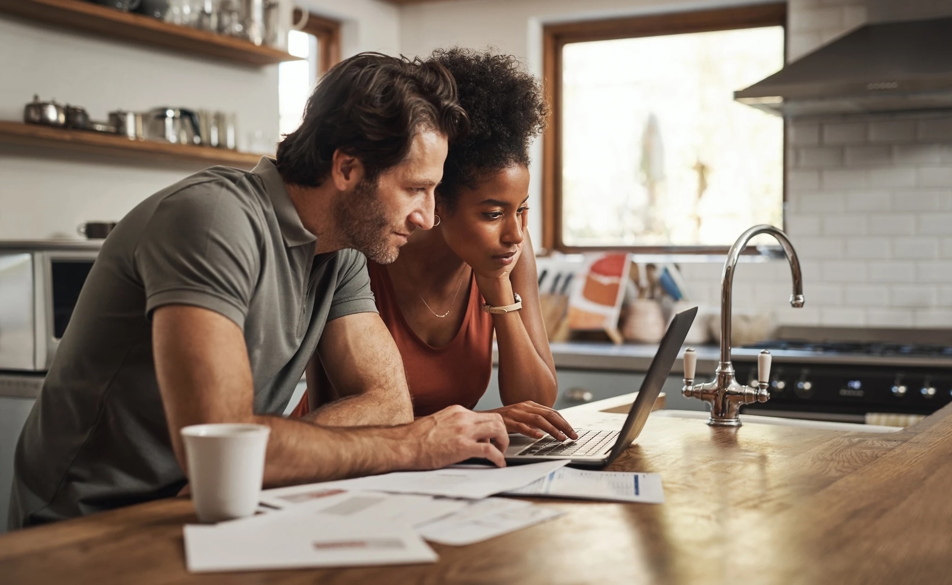 Couple comparing homeowners insurance quotes on their laptop