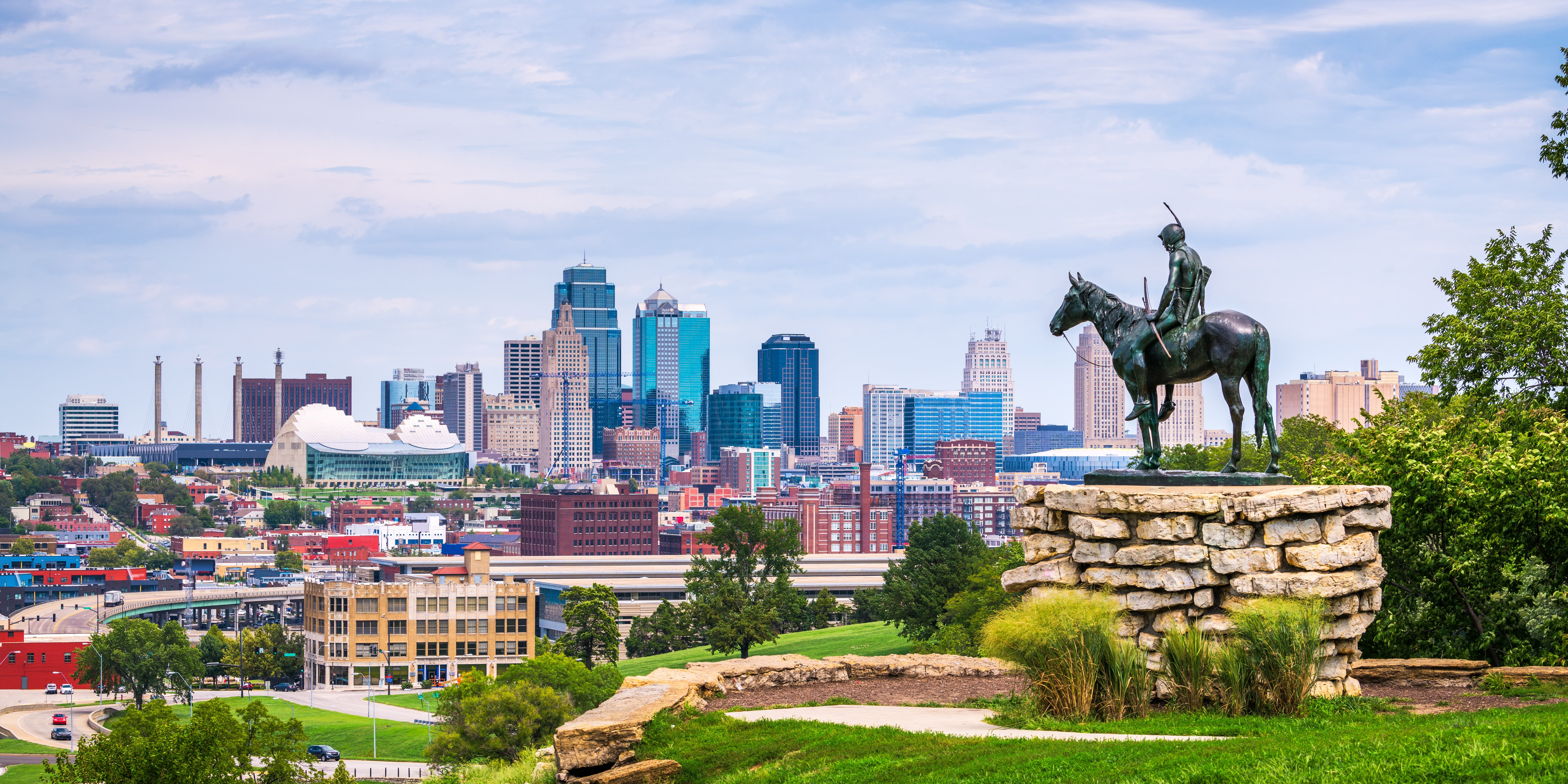 View of a statue in Kansas with a city in the background