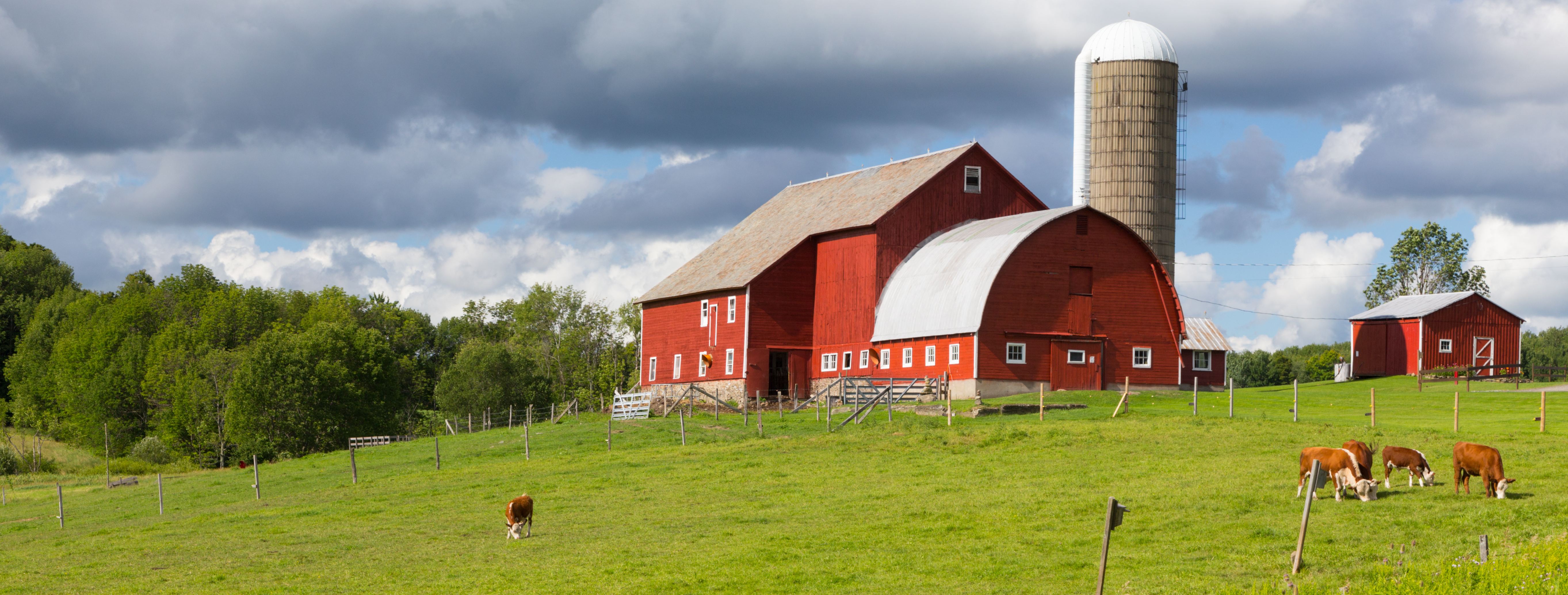 Big red barn in an Iowa field with a cloudy sky