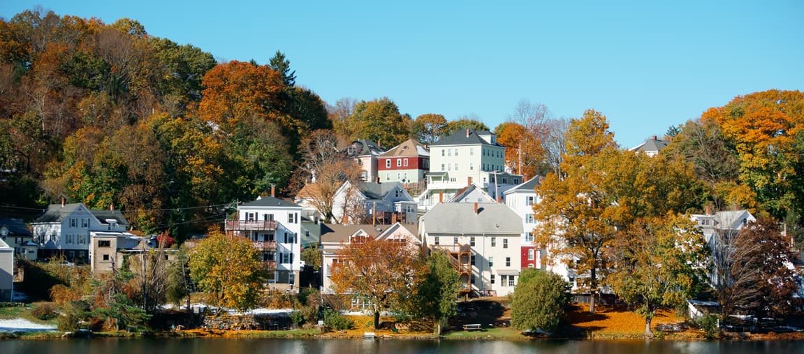 Row of houses on a hill with a lake in the foreground