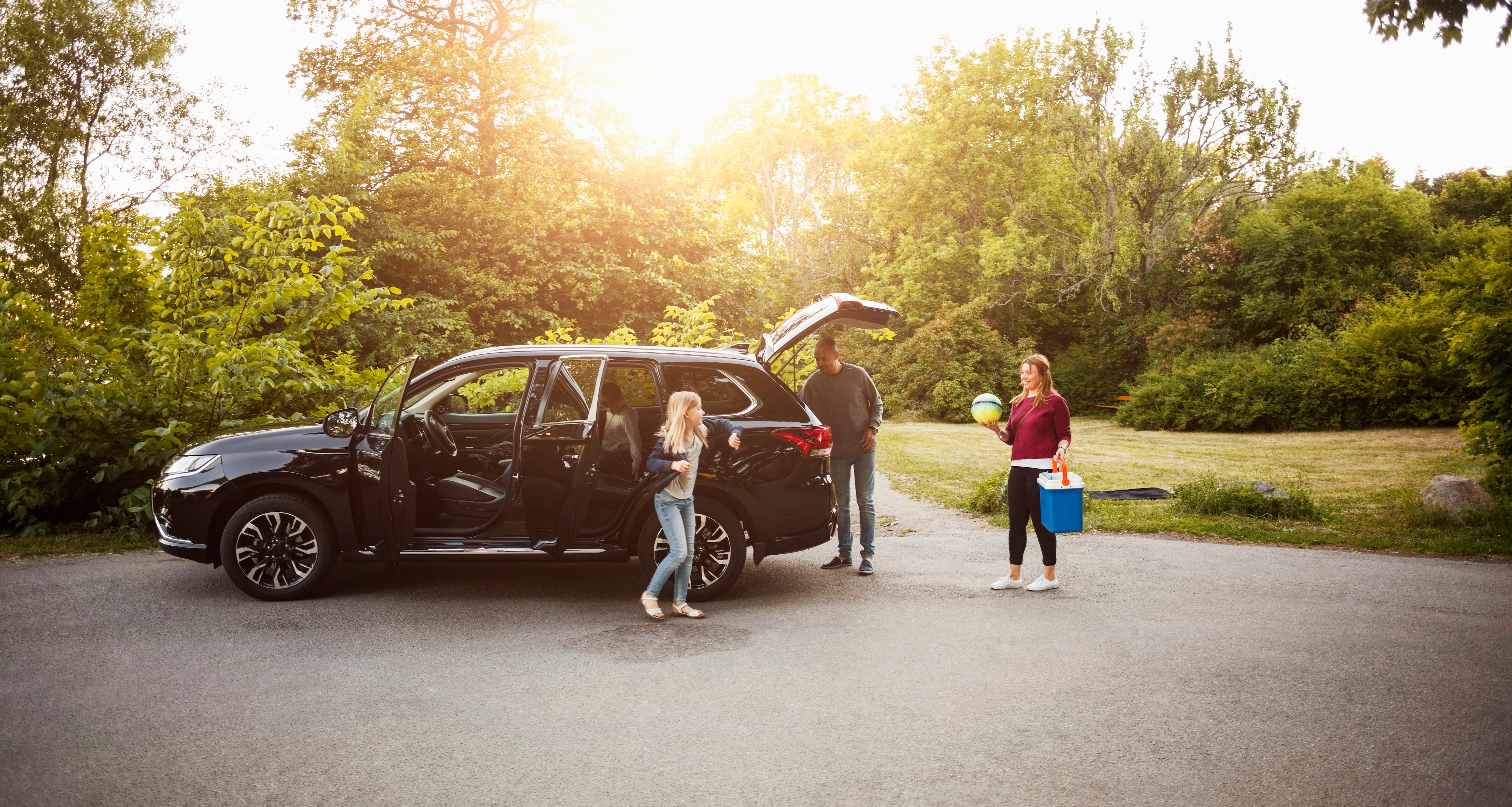 Family unloading SUV at a park in Pennsylvania on a sunny day.