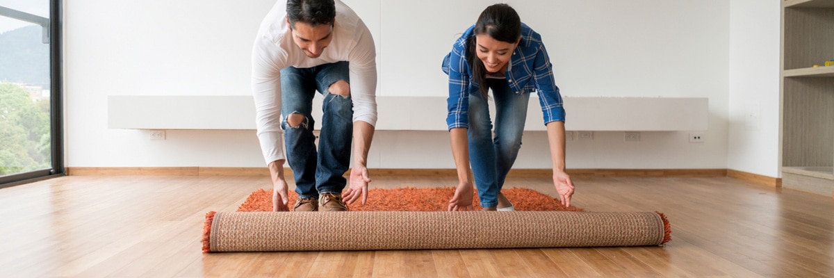 couple rolling out vintage rug couple rolling out vintage rug