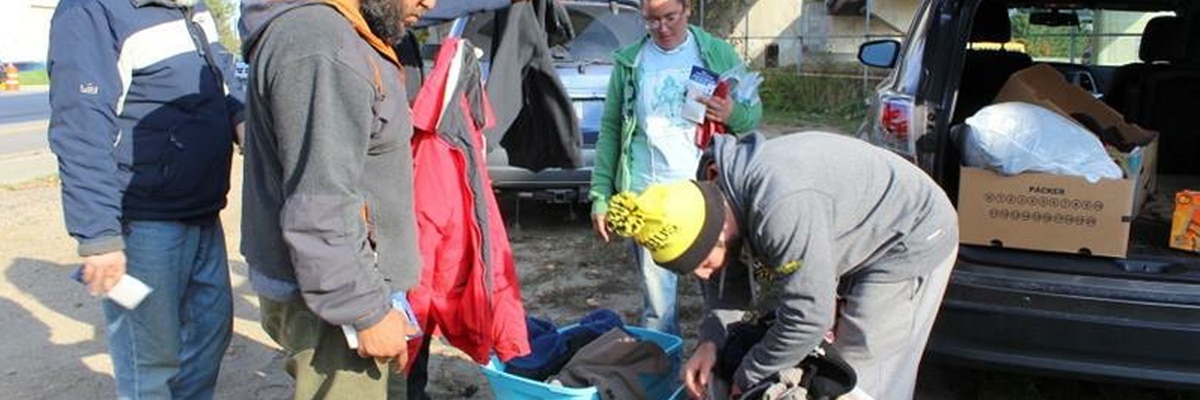 handing out winter clothing at a homeless camp