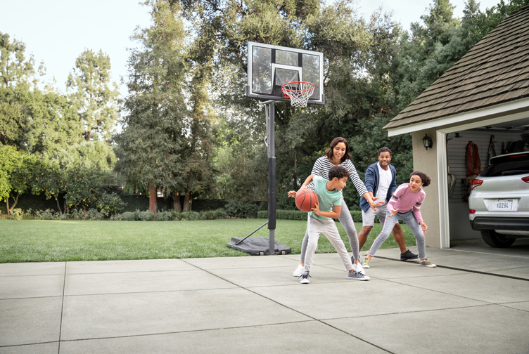 Familia juega baloncesto en la entrada.