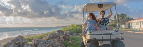 Couple in a golf cart driving on the course.