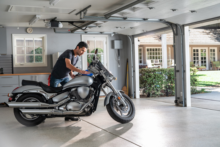 Man cleans motorcycle in his garage.