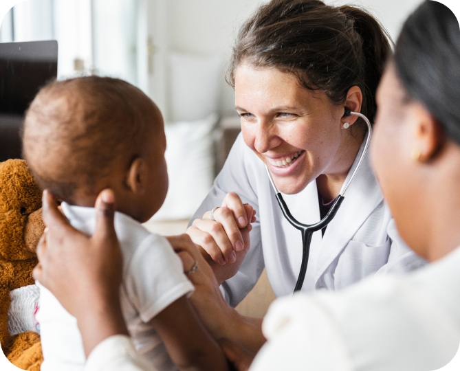 A woman wearing a stethoscope smiling at a baby.