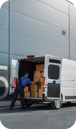 A man pulling boxes out of the back of a white cargo van