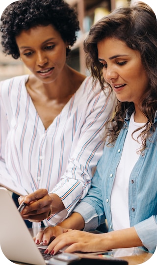 Two women working on a laptop computer.