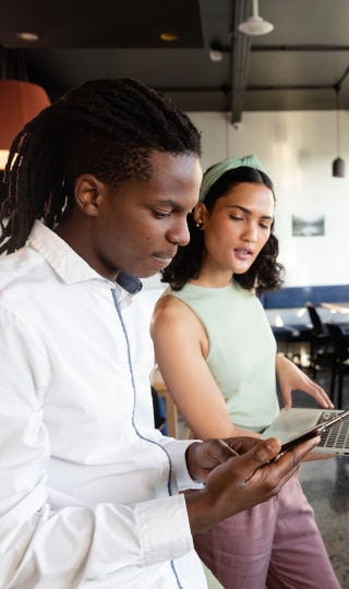 A Man and a woman looking at a tablet.