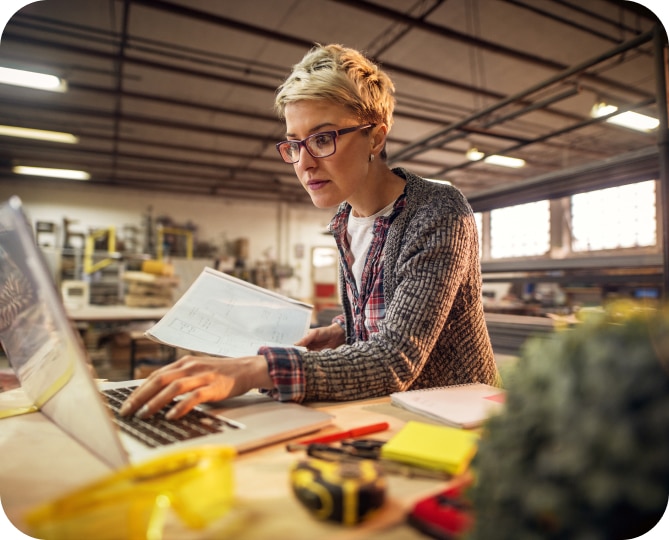 A Woman working at a desk on a computer.