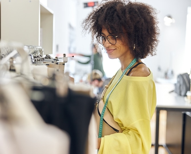 A woman looking at a rack of clothing.